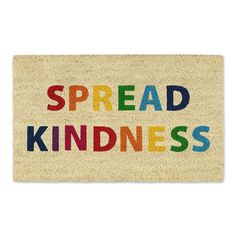 a door mat with the words spread kindness written in multicolored letters on it