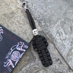 a skull keychain is tied to a rock