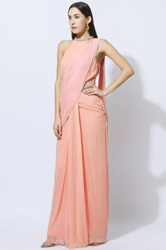 Peach saree-style draped gown with crystal and bead embellishment.
Components:1
Embellished
Neckline:Halter
Sleeve Length:Sleeveless
Fabric:Georgette
Color:Peach
Bead and sequin embellished hems
Sheer side and back
Pallu with beaded tassels
Closure: Side zip - Aza Fashions Elegant Peach Pre-draped Saree, Peach Pre-draped Saree For Party, Embellished Saree, Draped Gown, Peach Saree, Saree Style, Bead Embellishment, Drape Gowns, Gown For Women