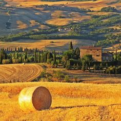 a field with hay bales in the foreground