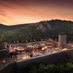 an outdoor dining area on the roof of a building with candles lit in front of it