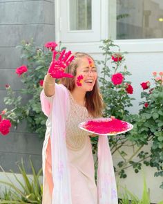 a girl with her hands painted pink and holding a plate