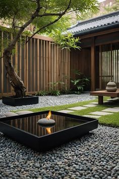 a small garden with rocks and stones on the ground next to a tree, bench and fire pit