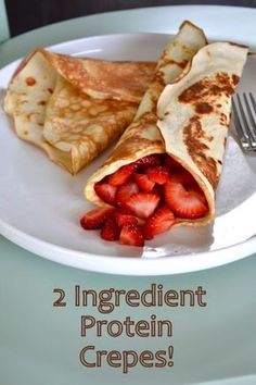 a white plate topped with crepes and strawberries