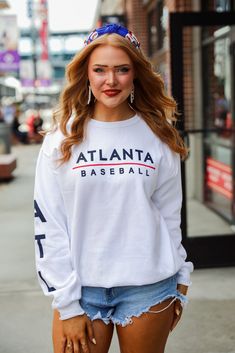 Calling all Braves fans, the White Atlanta Baseball Sweatshirt was made just for you! This comfy sweatshirt is designed with a soft and stretchy knit with a fleece interior. It features a crew neckline, long sleeves with "ATL" down them, a relaxed fit, and the words "Atlanta Baseball" on the front. Style the White Atlanta Baseball Sweatshirt with your favorite denim and a baseball hat for a cute game day look! Jerzees Brand Soft + Stretchy Knit Fabrication Fleece Interior "Atlanta Baseball" Grap Winter Varsity Long Sleeve T-shirt, White Stretch Crew Neck Sweatshirt, White Long Sleeve College Sweater, White Long Sleeve Sweater For College, White Stretch Sweatshirt With Letter Print, College Sweater With Letter Print And Long Sleeves, White Sweats For College In Winter, White Winter Sweats For College, Collegiate Crew Neck T-shirt For Winter