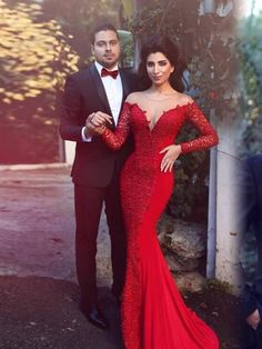 a man in a tuxedo standing next to a woman in a red dress