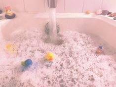 a bathtub filled with bubbles and rubber ducks