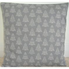 a gray and white pillow with trees on it