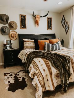 a bed room with a neatly made bed and animal heads on the wall above it