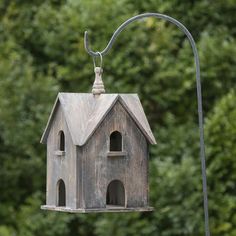 a bird house hanging from a metal pole