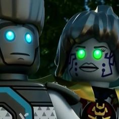 two legos with glowing green eyes standing next to each other in front of trees