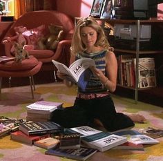 a woman sitting on the floor reading a book