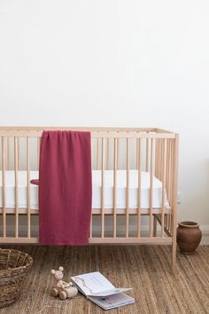 a baby crib with a pink blanket next to it