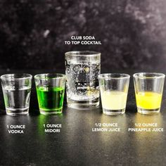 four shot glasses with different colored liquids in them