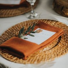 a place setting with an orange napkin on it