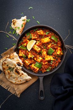 a pan filled with food next to some pita bread