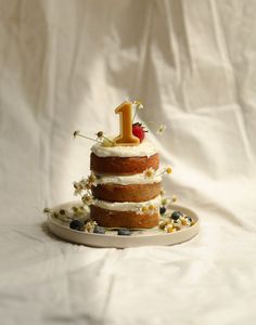 a three tiered cake with white frosting and blueberries is on a plate