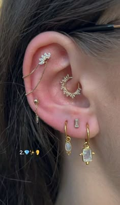 a woman wearing three different types of ear piercings