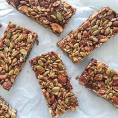 six pieces of granola bars on top of white paper with nuts and chocolate toppings