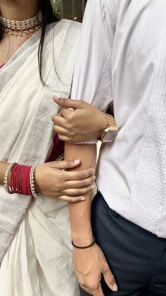 two people standing next to each other wearing bracelets