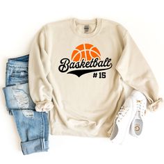 a sweatshirt with the word basketball on it and a pair of ripped jeans next to it