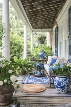 the porch is decorated with blue and white vases, potted plants, and wicker furniture