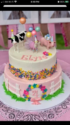 a birthday cake decorated with farm animals and balloons