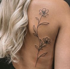 a woman's back tattoo with flowers on her left shoulder and the upper part of her body