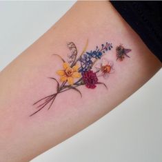 a woman's arm with flowers and butterflies tattooed on the left side of her body