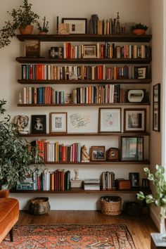 a living room filled with lots of books on shelves next to a plant and potted plants