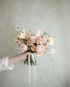 a person holding a bouquet of flowers in their hand