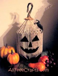 a basket with a jack - o - lantern on it next to pumpkins and grapes