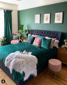 a bedroom with green walls and wooden flooring is decorated in shades of teal