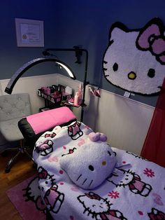 a hello kitty themed bedroom with pink and white bedding, black headboard, and chair