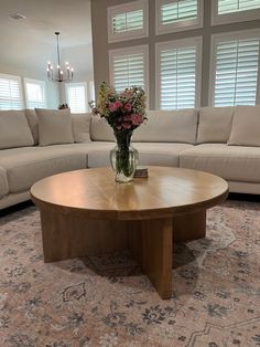 a living room with couches and a table in front of the sectional sofas