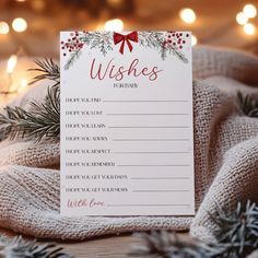 a christmas wish list on top of a wooden table next to pine cones and lights