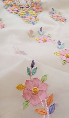 an embroidered table cloth with flowers on it