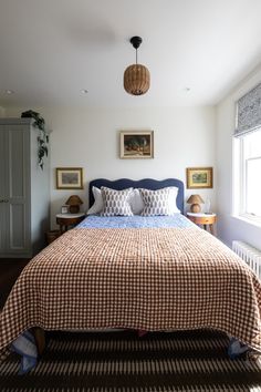 a bed sitting next to a window in a bedroom on top of a wooden floor