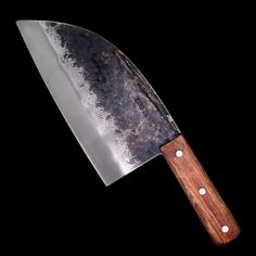 a large knife with a wooden handle on a black background and white dots around the blade