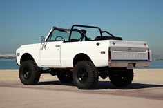 a white truck parked on top of a sandy beach