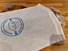 a loaf of bread sitting on top of a wooden table next to a paper bag