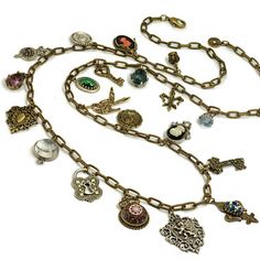 A Balkan fortune-teller would have worn such a mysterious necklace! Theornamental charms are full of intricate detail and antique elements.Sure to be an object of admiration and curiosity! Signed andcopyrighted Sweet Romance USA.Shown with SR_N1436 in second image Bohemian Charm Necklaces For Vintage Collection, Bohemian Jewelry With Vintage Charm For Collectors, Ornate Pendant Necklaces With Charms, Ornate Pendant Necklace With Charms, Vintage Brass Necklaces With Charms, Antique Locket Charm Necklace, Antique Handmade Pendant Charm Necklaces, Antique Charm Necklaces For Collectors, Vintage Charms For Jewelry Making Necklaces