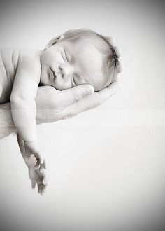 a black and white photo of a baby sleeping on someone's arm with the caption from flickr