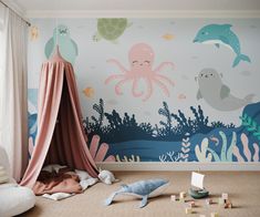 a child's room with an octopus and sea animals wall mural on the walls