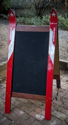 a red and white sign sitting on top of a sidewalk