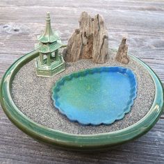 a small blue bowl sitting on top of a wooden table next to a tree stump