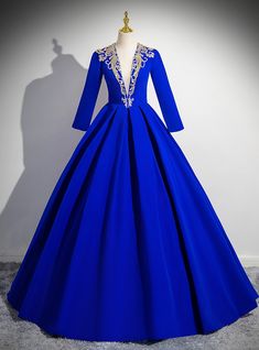 Ewaken your inner queen with this majestic royal blue gown! The rich hue of this dress instantly commands attention, while the stunning gold embroidery along the neckline adds a touch of opulence. The three-quarter sleeves bring an air of elegance, making this dress ideal for those who want a balance between modesty and glamour. The full skirt flows effortlessly, creating a graceful and dramatic silhouette as you move. Whether you're attending prom, a formal event, or any special occasion, this dress will make you feel like royalty. The deep neckline with ornate detailing is the perfect combination of bold and sophisticated, ensuring that all eyes will be on you throughout the night. Royal Blue Wedding Dress, Long Sleeve Quinceanera Dresses, Royal Blue Gown, Blue Wedding Dress, Quinceanera Dresses Blue, Special Occasion Gowns, Princess Prom Dresses, Mother Of The Bride Gown, Royal Blue Wedding