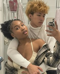 a young man taking a selfie with his girlfriend in front of a bathroom mirror