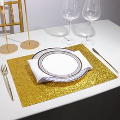 a place setting with gold sequins and white plates