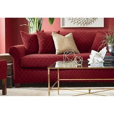 a living room with red couches and pillows on top of the couch is shown